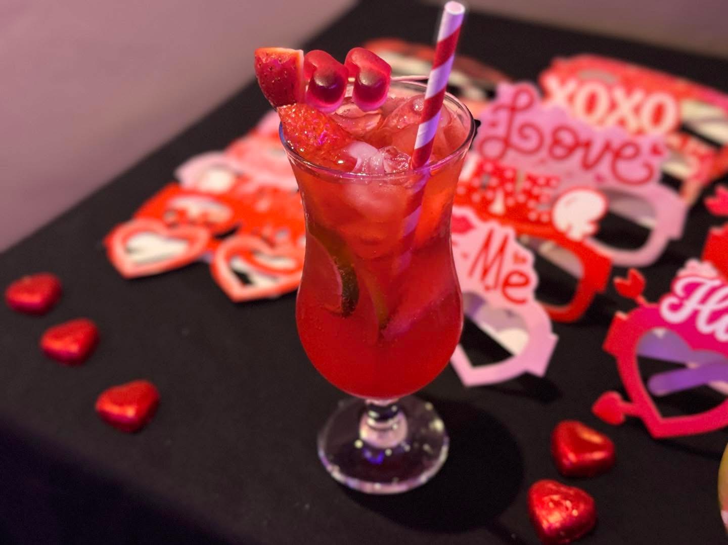 Red Valentine's cocktail surrounded by heart decorations at Fusion Spice